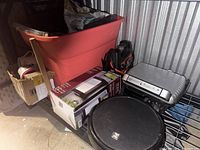 Wide view of large red storage bin, boxed LED light fixture, iLife robot vacuum, and George Foreman grill on shelf