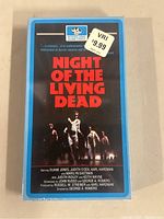 Front view of sealed VHS tape Night Of The Living Dead showing title, cover art with zombie figures, and price sticker.