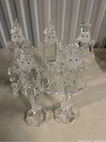 Front view of five clear glass Nutcracker figurines showing detailed craftsmanship and painted facial features.