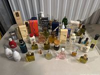 Full view of the perfume lot on a table showing multiple bottles and boxed perfumes arranged in rows.