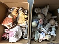 Box containing mixed porcelain figurines, rabbit, girl in yellow dress and other figures visible