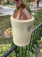 Full view of the crock showing the two-tone glazed and unglazed surface with handle.