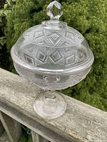 Full view of the early American pressed glass covered compote showing the footed pedestal base, bowl, and lid with faceted knob.