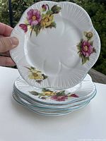 Stack of 6 Shelley Begonia side plates with visible floral pattern.