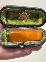 Amber smoking tip in its original black velvet-lined case with gold Star of David and SIM branding inside lid