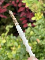 Close-up of the mother of pearl handle with nubs resembling a rose stem and gold etched tip.