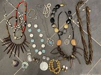 Full view showing all jewelry pieces in the lot including multiple necklaces, earrings, bracelets and pendants.