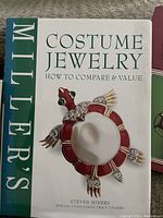 Photo of the book 'Costume Jewelry: How to Compare & Value' by Steven Miners with cover image showing a red and white jewelled turtle brooch.