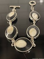 Photo of reversible bracelet with oval onyx and mother of pearl inlaid links.