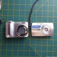 Front view of Kodak EasyShare C875 and Olympus Stylus 700 digital cameras showing lenses and branding.