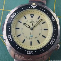 Close-up of the dial showing Timex Indiglo branding, cream dial, black markers and hands, bezel with minute markers.