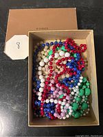 Photo of 8 colorful bead necklaces in a box from an overhead view