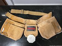 Leather Craftsman tool belt with multiple pockets and fabric adjustable strap.