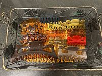 Photo of 11 hair clips of varying sizes and colors, some smooth and some fuzzy, arranged in a decorative wire basket.