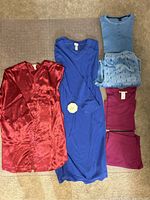 Four women's sleepwear items laid out on floor: red silky nightie, blue fleece nightie, blue pajama set with patterned pants and shirt, purple pajama set