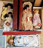 Five vintage Dynasty porcelain dolls in original boxes with tags visible, variety of period-style dresses with lace and ribbons, dolls have painted faces and glass eyes