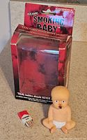 Ceramic baby incense holder outside original box packaging on carpeted floor.