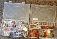 Two open plastic containers showing many compartments filled with various sizes and shapes of carnelian beads and jewelry parts.