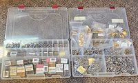 Overview of two plastic containers displaying multiple compartments filled with metal jewelry supplies and boxes of seed beads