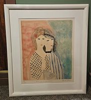 Framed lithograph of two stylized women by David Stein shown hanging on green wall.