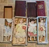 Four dolls in original boxes with one box lid damaged
