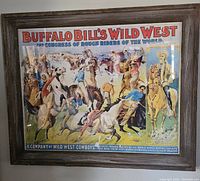 Full view of the framed Buffalo Bill's Wild West poster showing multiple riders and action scenes inside a rustic wooden frame.