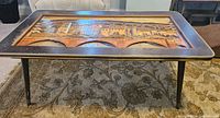 Full view of wooden coffee table with carved cityscape tabletop