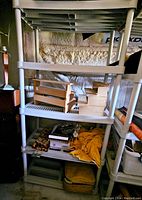 Full view of assembled shelving unit holding various empty crates and loose items, showing scale and condition.