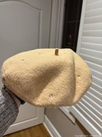 Side angle showing the overall shape and some of the gem decorations on the camel colored wool beret.