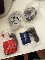 Four unopened airplane headset packages and one small blue Air Transat ear plug pouch laid out on a white surface.