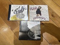 Photo of three CD covers on wooden floor showing front covers of Plan by Silwia Przybysz, Fidl by Alicia Svigals, Romanian Fantasy by Marilyn Lerner