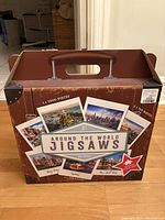 Suitcase-style box showing packaging and some puzzle images and city names