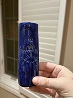 Front view showing deep blue glazed clay mezuzah case with etched synagogue domes and Star of David detail.