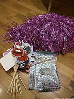 Metallic pink fringe backdrop and Taylor Swift-themed photo booth props including lips, musical notes, and other shapes on sticks, with silver glitter confetti packs.