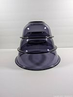 Three nested Pyrex mixing bowls stacked to show size progression and nesting ability.