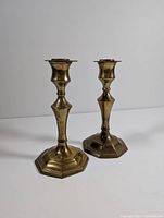 Pair of vintage brass candlestick holders, front and side view showing shape and height.