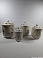 Full set of four ceramic floral canisters of varying sizes