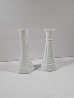 Front view of two milk glass vases showing shapes and textures.