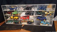 Full display case showing 16 die cast vintage cars arranged in rows