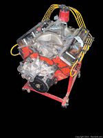 Front view of orange-painted Chevrolet V8 engine on red rolling engine stand