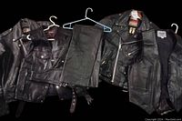 Overview of two jackets, two vests and two chaps laid out