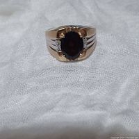 Front view showing oval garnet center and side diamond chips