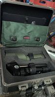 Carrying case open, showing foam cutouts holding spotting scope, tripod, and soft pouch.