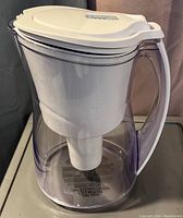 Clear Brita water filtration jug showing the filter compartment inside and the white handle.