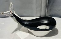 Black and white glass orca killer whale figurine, side view showing smooth glossy finish and details.