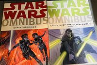 Two Star Wars Omnibus hardcover books, Early Victories and Knights of the Old Republic Volume 1, shown side by side on a wooden surface, with detailed cover art visible.
