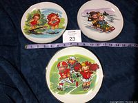 Front view of the three Campbell Kid collector plates showing colorful scenes of kids playing outdoors.