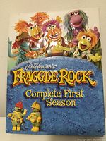 Front cover of the Fraggle Rock Complete First Season DVD box set showing colorful puppet characters and title.