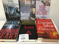 Front covers of 7 hardcover books laid out in a single row showing titles and authors.