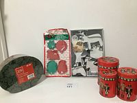 Photo showing all items: 3 green decorative gift boxes, 3 red nutcracker-themed tins, and 2 sets of cookie cutters (metal and plastic)